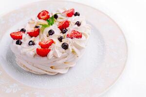 Pavlova cakes with cream and fresh berries on plate photo