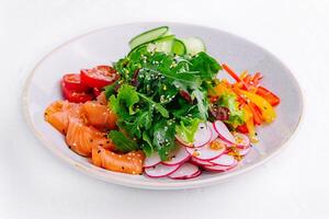 Smoked or salted salmon salad with cucumbers, arugula, peppers and radishes photo