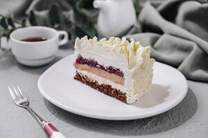 Layered Mousse Cake on white plate and cup of tea photo