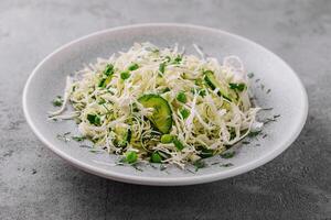 Spring vegan salad with cabbage, cucumber, green onion and peas photo