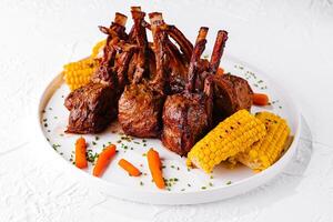 rack of lamb with corn and carrots photo