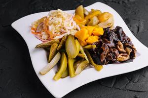 Marinated salty vegetables in the plate photo