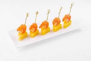 Canapes with shrimp and pineapple on plate photo