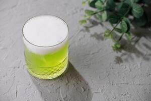 Glass of green soda on top view photo