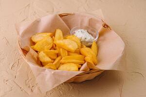 Potato wedges in basket and sauce photo