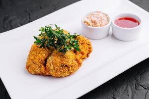 Chicken schnitzel with sauce on plate photo