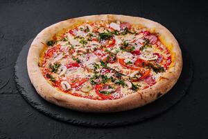 Delicious freshly baked pizzas on black plate photo