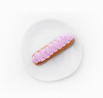 Eclair dessert with pink whipped cream on plate photo