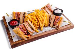 Mini sandwiches with ham and fries with sauces photo