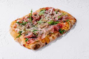 square pizza with prosciutto and arugula photo