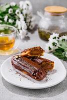 Tasty eclairs and cup of tea photo