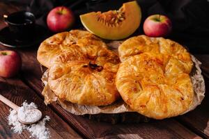 Cooking traditional pies with apple and pumpkin on wooden board photo