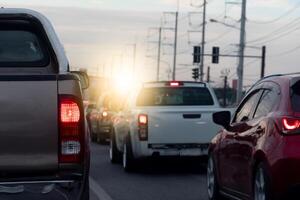 Rear side of pickup car with turn on brake light on asphalt roads. During rush hours for travel or business work. Environment of traffic jam with many cars. photo