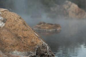 rocas saliente encima el superficie de el agua en Chaeson caliente primavera. con un Delgado capa de vapor. a chae hijo nacional parque tailandia foto