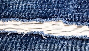 AI generated A close-up of a torn section in blue denim fabric, revealing the white threads underneath photo