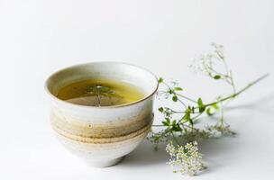 ai generado taza de verde té y hierba en blanco antecedentes foto