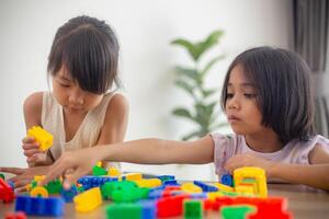 Adorable little girl playing toy blocks in a bright room photo