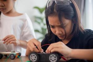 inventivo niños aprender a hogar por codificación robot carros y electrónico tablero cables en provenir. construyendo robot carros a hogar foto