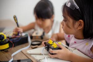 nventive kids learn at home by coding robot cars and electronic board cables in STEM. constructing robot cars at home photo