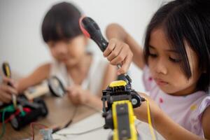 inventivo niños aprender a hogar por codificación robot carros y electrónico tablero cables en provenir. construyendo robot carros a hogar foto