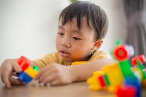 Cute little boy playing with colorful toys photo