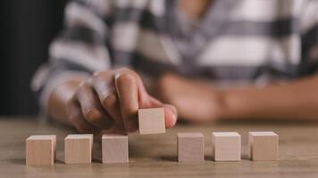 Businesswomen stack blank wooden cubes on the table with copy space, empty wooden cubes for input wording, and an infographic icon. photo