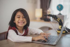 vástago educación concepto. asiático estudiantes aprender a hogar por codificación robot brazos en provenir, matemáticas Ingenieria Ciencias tecnología computadora código en robótica para niños' conceptos. foto