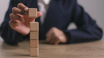 Businesswomen stack blank wooden cubes on the table with copy space, empty wooden cubes for input wording, and an infographic icon. photo