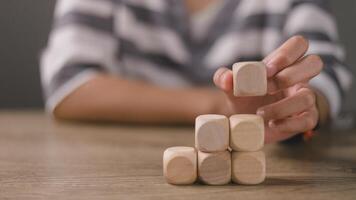 mujer de negocios apilar blanco de madera cubitos en el mesa con Copiar espacio, vacío de madera cubitos para entrada fraseología, y un infografía icono. foto