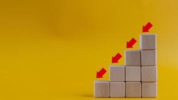 Business decrease concept abstract yellow background. Red arrow and wooden stairs bock photo