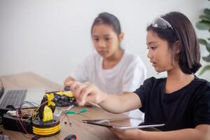 nventive kids learn at home by coding robot cars and electronic board cables in STEM. constructing robot cars at home photo