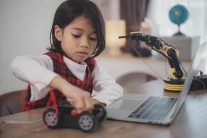 vástago educación concepto. asiático estudiantes aprender a hogar por codificación robot brazos en provenir, matemáticas Ingenieria Ciencias tecnología computadora código en robótica para niños' conceptos. foto