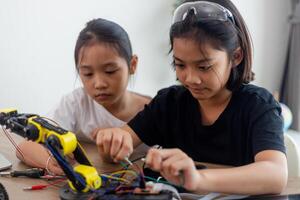 inventivo niños aprender a hogar por codificación robot carros y electrónico tablero cables en provenir. construyendo robot carros a hogar foto