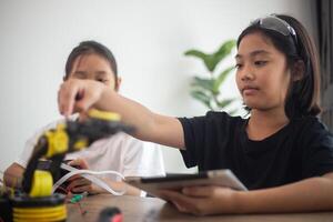 nventive kids learn at home by coding robot cars and electronic board cables in STEM. constructing robot cars at home photo