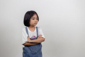 Angry little girl over white background, sign and gesture concept photo