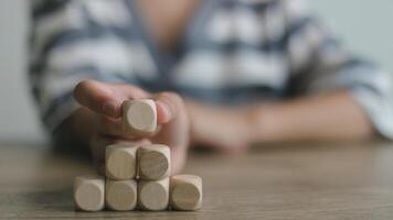 Businesswomen stack blank wooden cubes on the table with copy space, empty wooden cubes for input wording, and an infographic icon. photo