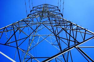 Steel electricity Pylon and High Voltage Power line Electricity transmission photo with blue sky background.