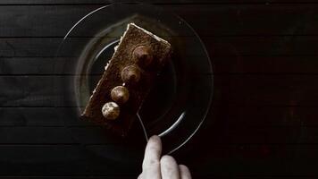corte un pedazo de trufa pastel con un tenedor en un oscuro antecedentes. video