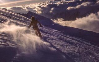 a person riding a snowboard down a mountain photo