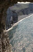 a view of a cliff and ocean from inside a cave photo