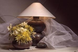 a table with a lamp and a vase of flowers photo