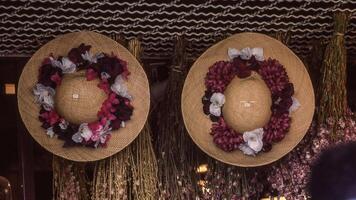 two hats with flowers on them are hanging on a wall photo