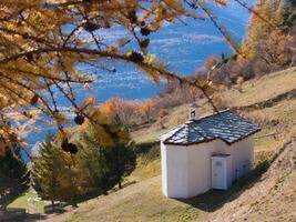 a small white house on a hillside photo