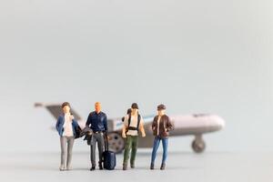 Miniature people, travelers embarks on a delightful vacation, gleefully boarding a tiny airplane photo