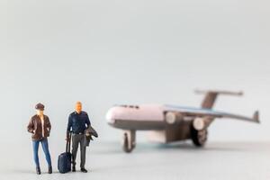 Miniature people, travelers embarks on a delightful vacation, gleefully boarding a tiny airplane photo