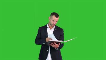 un' uomo guardare documenti su verde sfondo video