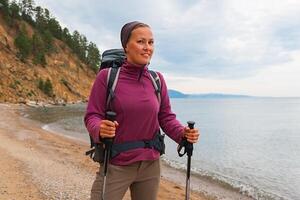 Hiking tourism adventure. Backpacker hiker woman looking at beautiful view. Hiker girl lady tourist with backpack walking near lake. Young happy woman enjoy hike trekking tourism active vacation photo