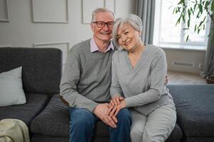 Senior adult mature couple hugging at home. Mid age old husband and wife embracing with tenderness love enjoying sweet bonding wellbeing. Grandmother grandfather together. Family moment love and care photo