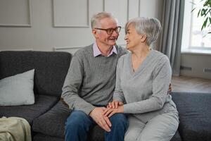 Senior adult mature couple hugging at home. Mid age old husband and wife embracing with tenderness love enjoying sweet bonding wellbeing. Grandmother grandfather together. Family moment love and care photo