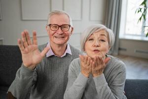 Happy senior woman man talk on video call with friends family. Mature old grandmother grandfather talking speaking with grown up children online. Older generation modern tech usage. Webcamera view photo